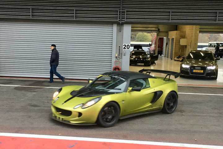 A green Lotus Elise in the pit lane at a track day