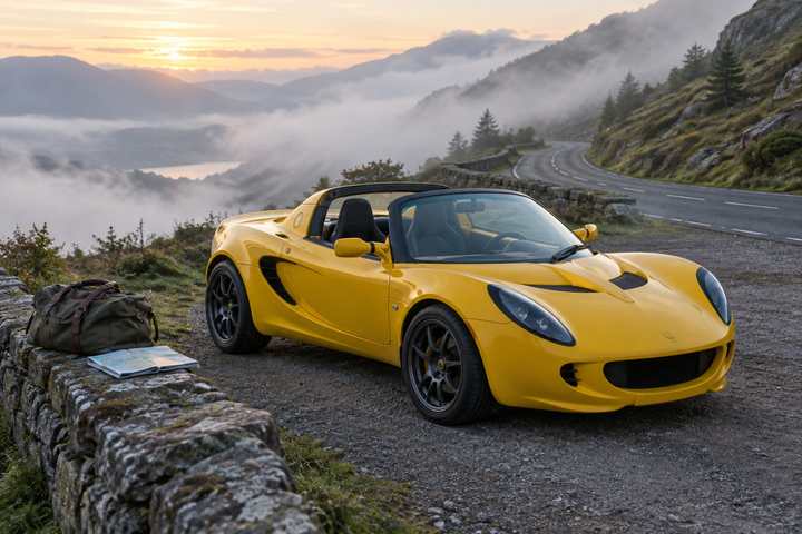 A yellow roadster parked at a mountain lay-by at dawn with a soft bag and a road map on the wall beside it