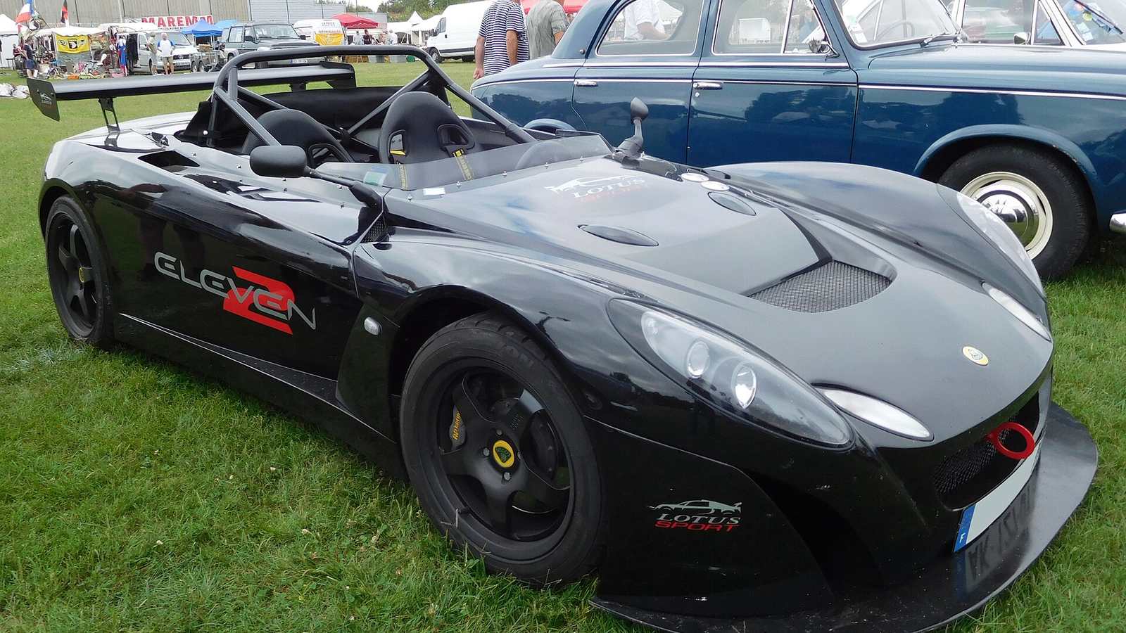 A black Lotus 2-Eleven track car on grass