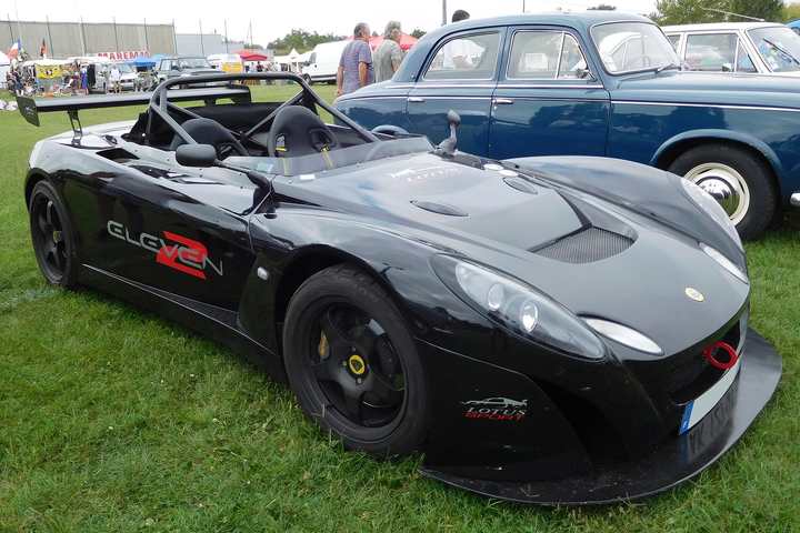 A black Lotus 2-Eleven track car on grass