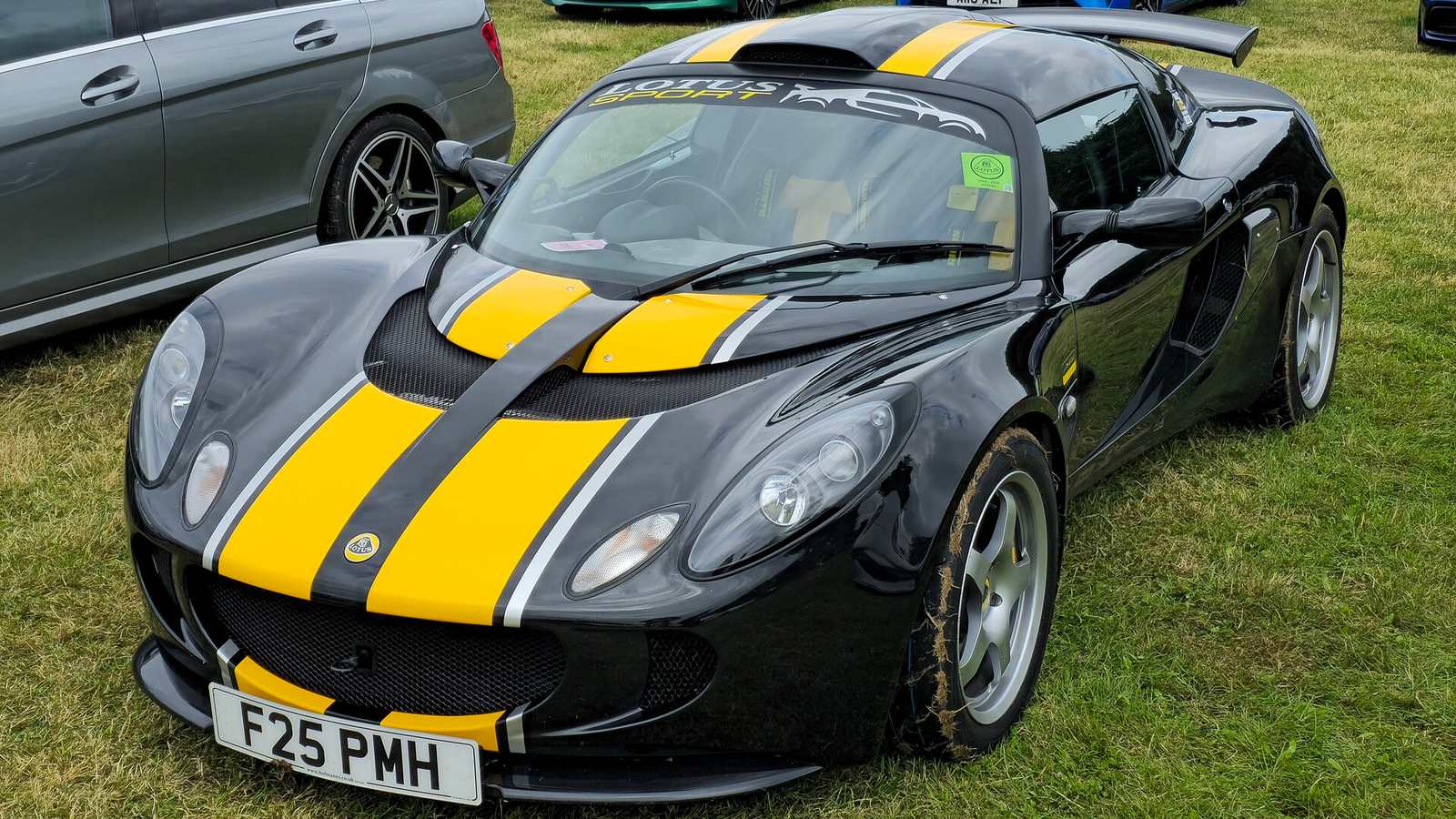 A black Lotus Exige S Series 2 with yellow stripes