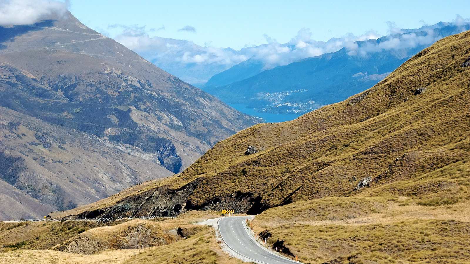 The Crown Range Road curving across tussock hills in New Zealand