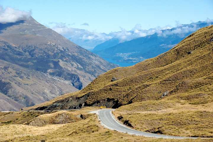 The Crown Range Road curving across tussock hills in New Zealand