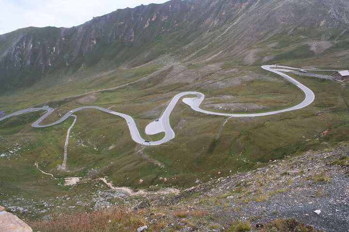 Hairpin bends of the Grossglockner High Alpine Road crossing a green mountainside