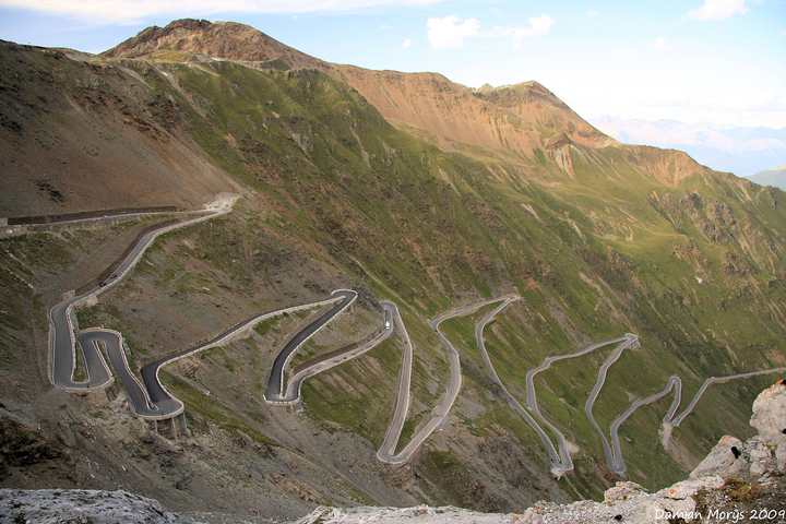 The stacked hairpin bends of the Stelvio Pass climbing the valley wall above Trafoi